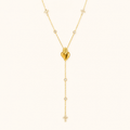 Gold heart zircon Y necklace on a warm cream background