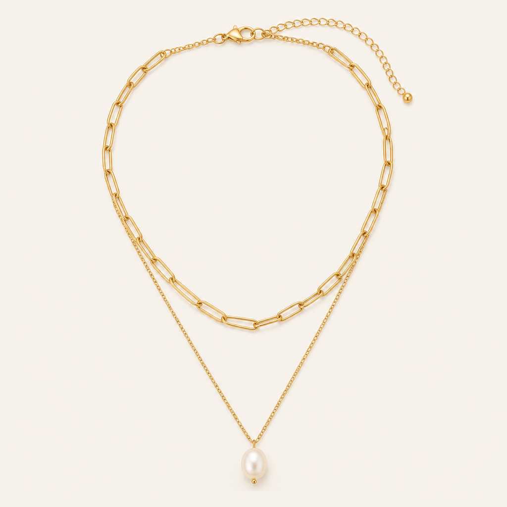 Gold layered pearl necklace on a warm cream background
