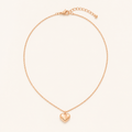 Rose gold heart pendant necklace on a warm cream background