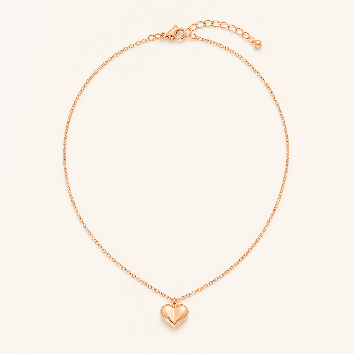 Rose gold heart pendant necklace on a warm cream background