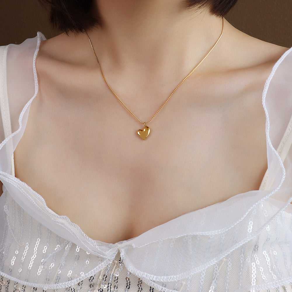 Model wearing the Carried With Love Heart Necklace in gold